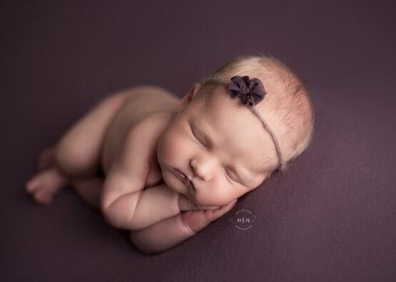 troy michigan newborn photographer melissa anne photography baby girl side laying with purple headband