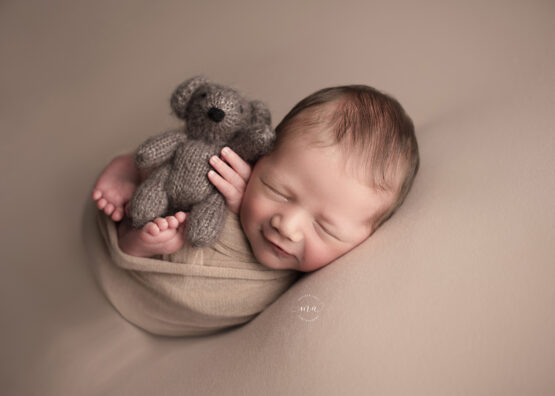 troy michigan newborn photographer melissa anne photography wrapped baby with bear smiling