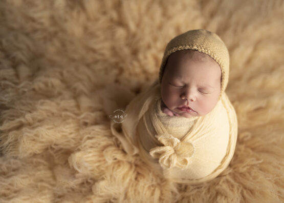 michigan newborn photographer melissa anne photography baby girl with bonnet potato sack pose yellow