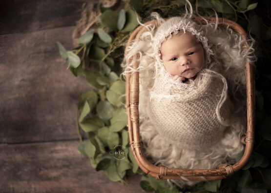michigan newborn photographer melissa anne photography baby girl wrapped boho basket awake