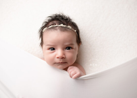 Michigan newborn photographer Melissa Anne Photography baby girl with headband tucked in pose