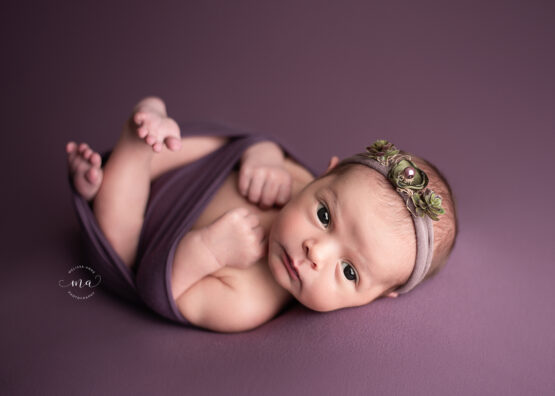 Michigan newborn photographer Melissa Anne Photography Huck Finn pose dark purple baby girl with eyes open