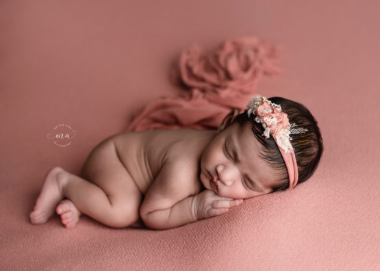 Michigan newborn photographer Melissa Anne Photography baby girl with dark hair coral backdrop