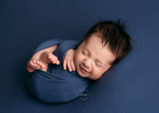 Michigan newborn photographer Melissa Anne Photography Huck Finn pose dark blue baby boy with dark hair