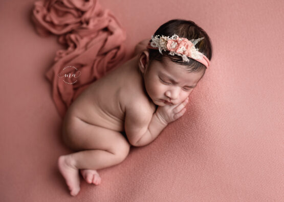 Michigan newborn photographer Melissa Anne Photography side lay pose on coral backdrop