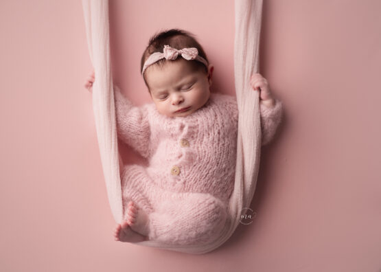 Michigan newborn photographer Melissa Anne Photography baby girl in swing pink knit pajamas