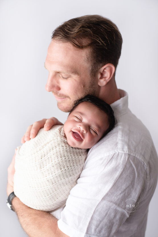 Troy Michigan newborn photographer Melissa Anne Photography dad with baby boy smiling