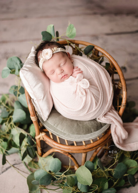 Troy Michigan newborn photographer Melissa Anne Photography potato sack wrap on wicker chair with greenery