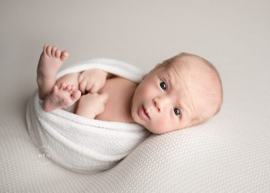 Troy Michigan newborn photographer Melissa Anne Photography wrapped baby Huck Finn pose on cream backdrop