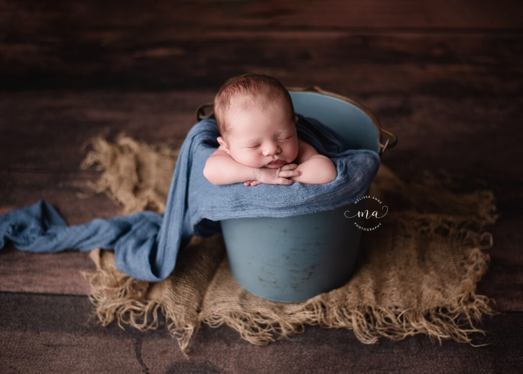 Michigan newborn photographer Melissa Anne Photography cute baby boy in blue bucket wood floor