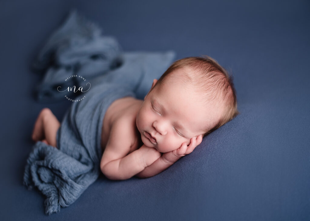Michigan newborn photographer Melissa Anne Photography newborn boy on blue background with wrap