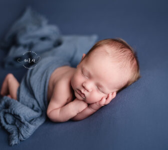 Michigan newborn photographer Melissa Anne Photography newborn boy on blue background with wrap