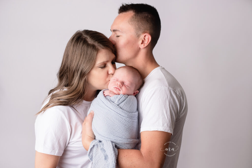 Michigan newborn photography Melissa Anne Photography parents with newborn baby boy in studio photo on all white