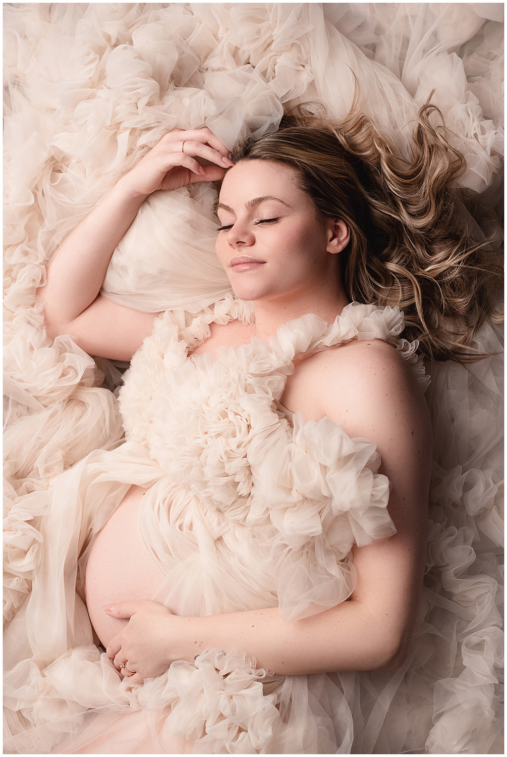 Metro-Detroit-Maternity-Photographer-Melissa-Anne_Photography-pregnant-mother-in-neutral-tulle-couture-gown-laying-down-with-eyes-closed-and-hair-flowing