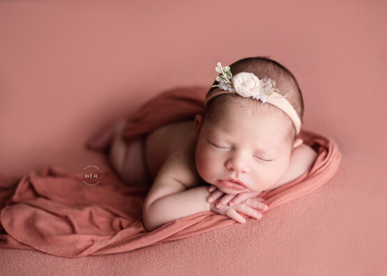 Birmingham Michigan newborn photographer Melissa Anne Photography coral backdrop with baby girl forward facing