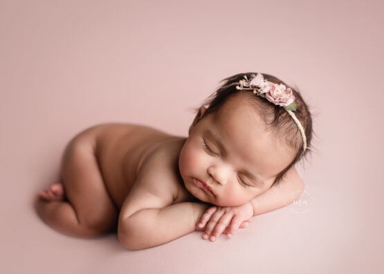 Troy Michigan newborn photographer Melissa Anne Photography baby girl with dark hair on pink in bum up pose