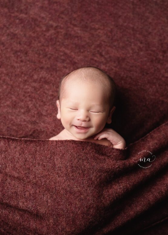 Troy Michigan newborn photographer Melissa Anne Photography baby smiling tucked in pose