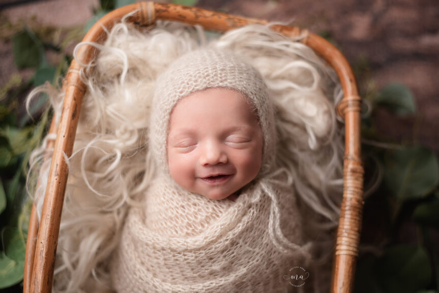 Birmingham Michigan newborn photographer Melissa Anne Photography baby newborn boy swaddled in basket smiling