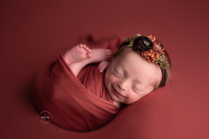 Troy Michigan newborn photographer Melissa Anne Photography baby girl smiling with floral headband