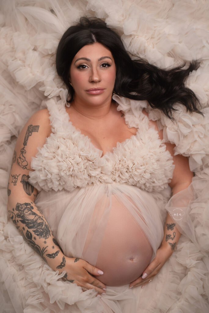 Troy Michigan maternity newborn photographer Melissa Anne Photography laying down in cream tulle gown