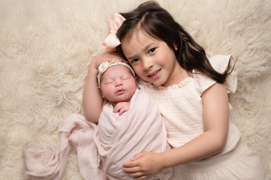 Waterford Michigan newborn photographer Melissa Anne Photography baby with big sister on cream background